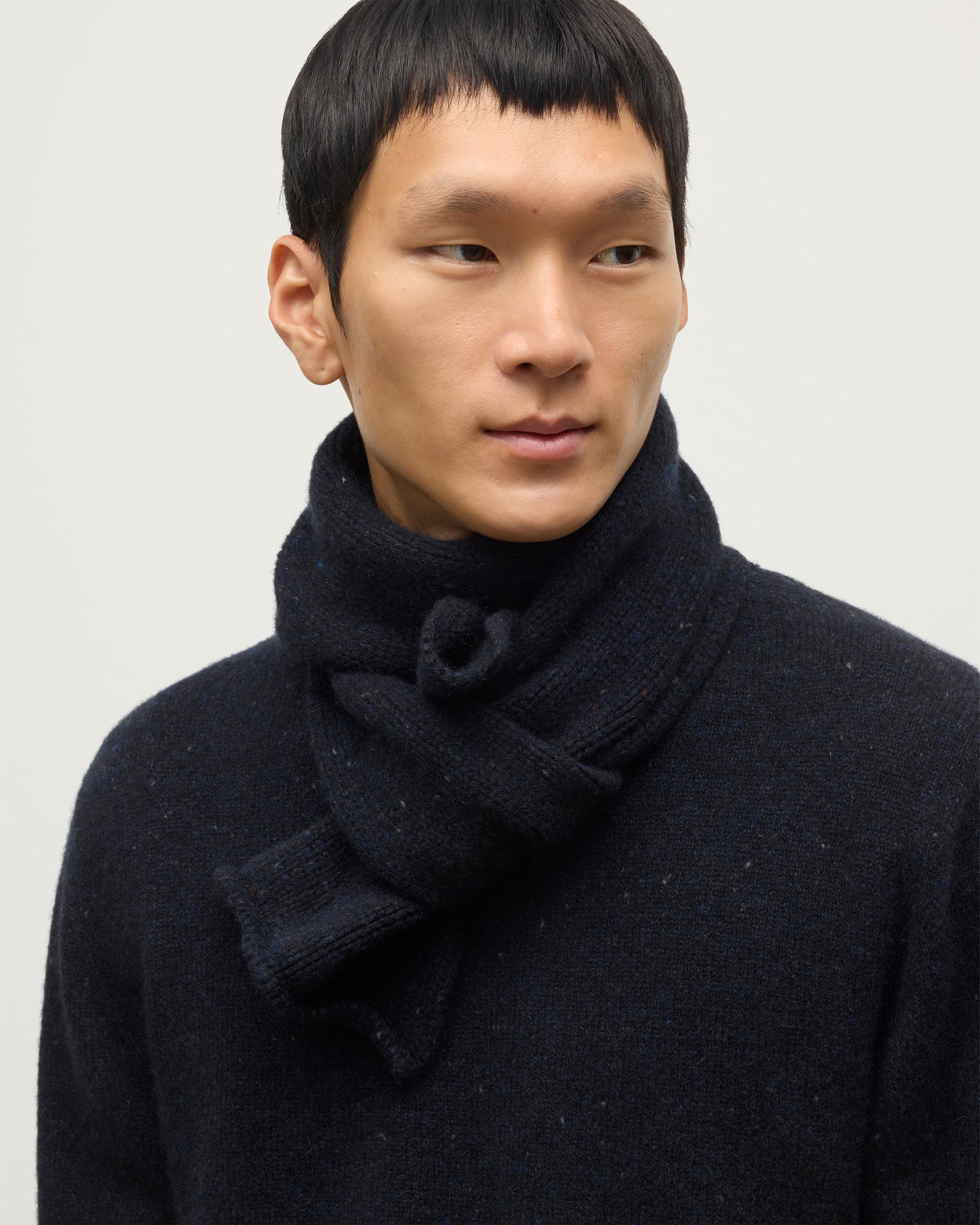 MODEL WEARING JOHNSTONS OF ELGIN TIREE SCARF 100% CASHMERE WITH MATCHING TIREE CASHMERE SWEATER IN NORTHSCAPE DONEGAL HAC03622HD7348ONE