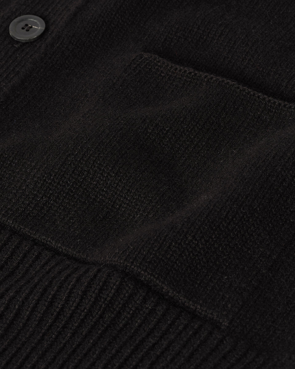 Johnstons of Elgin AW25 Men's Knitwear Black Ribbed Cashmere Black Cardigan worn over a black t-shirt, showing button details KAC05601SA7210