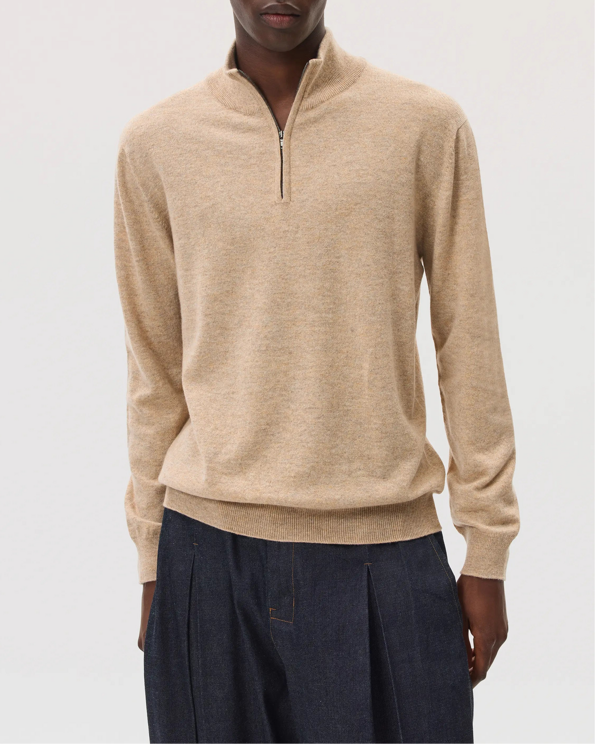 Model wearing Johnstons of Elgin SS25 Men's Knitwear Oatmeal Classic Cashmere Zip Neck on a white background KAI05151HB0210