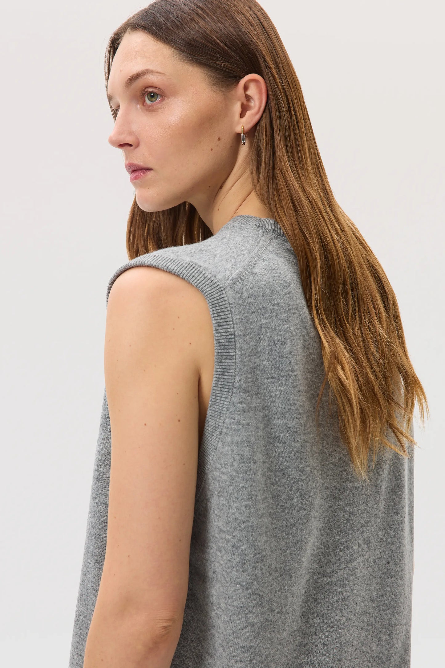 Female model wearing Johnstons of Elgin SS25 Unisex Knitwear Light Grey Cashmere Tank against a white background KAP05243HA0308