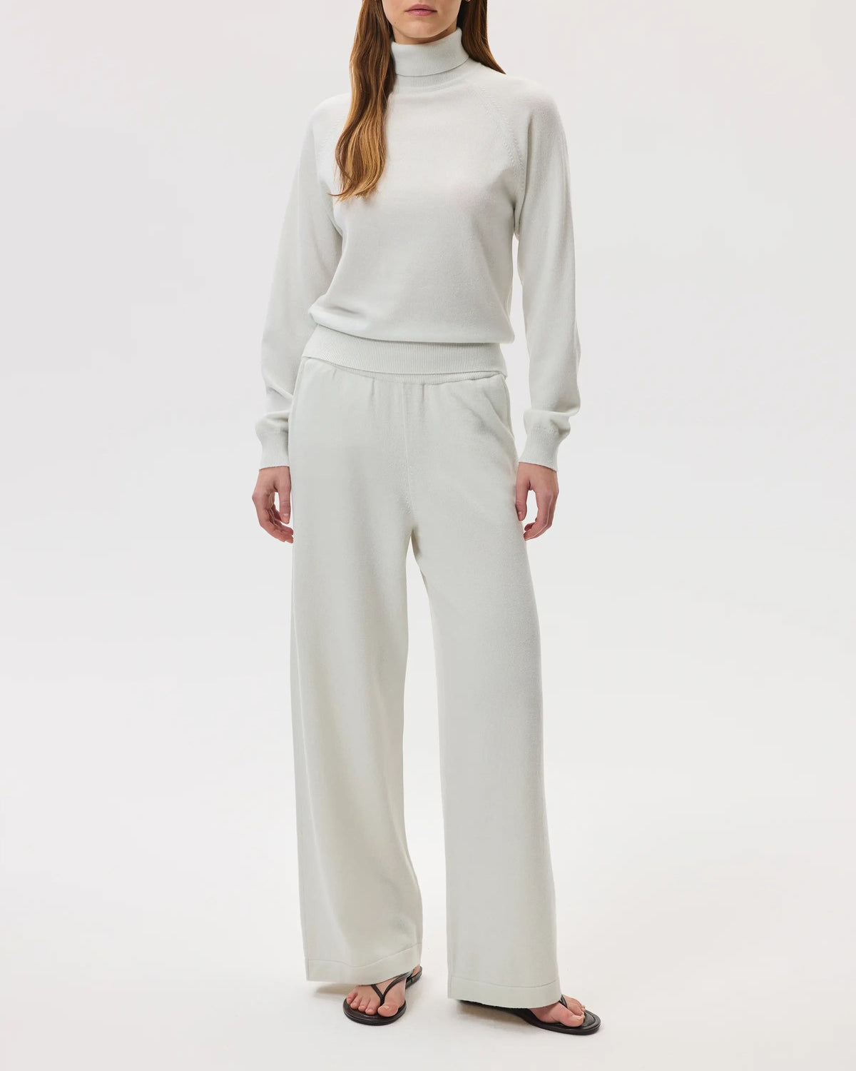 Model wears Johnstons of Elgin SS25 Women's Knitwear White Classic Cashmere Roll Neck Sweater with
matching cashmere culottes on a white backdrop KAP05275HA0346