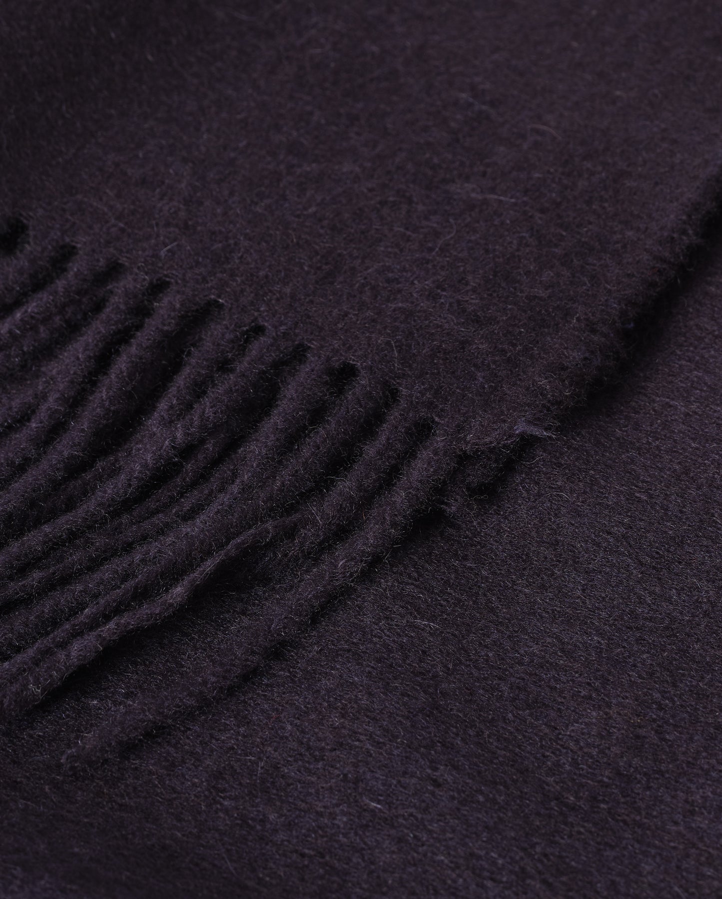 Johnstons of Elgin Interiors Collection Dark Navy Cashmere Throw on a wooden chair WA000055SD7330ONE