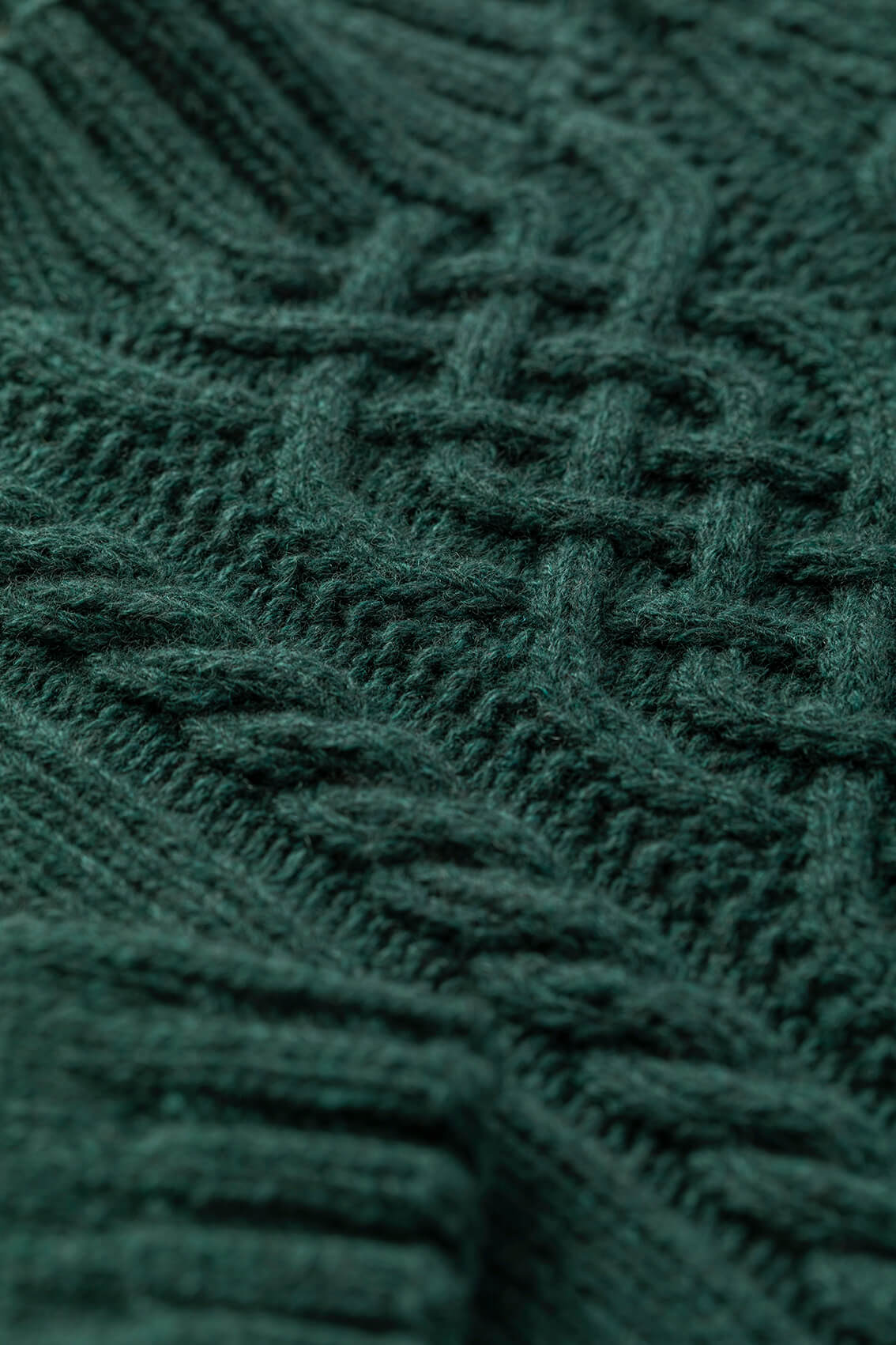 Johnstons of Elgin children's cashmere sweater in dark green lying on a white background JA000106HC4103
