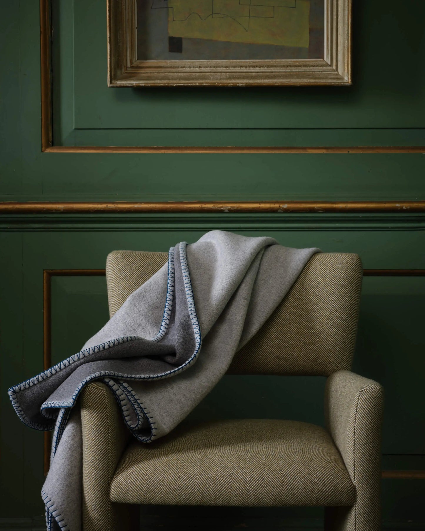 2025 Johnstons of Elgin Interiors Collection Silver & Grey Reversible Blanket Stitched Throw on an upholstered chair  TB000500RU7560ONE