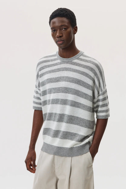 Male model wearing Johnstons of Elgin SS25 Unisex Knitwear Light Grey & White Textured Stripe Oversized Cashmere T-Shirt on a white backdrop KAA05414Q25124