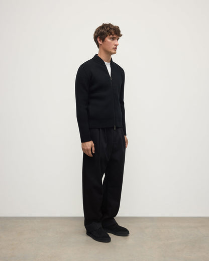 Johnstons of Elgin AW25 Men's Knitwear Black Cashmere Milano Stitch Zip Jacket with black trousers and a white t-shirt  KAA05443SA0900