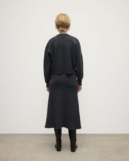 Model wearing Johnstons of Elgin AW25 Women's Knitwear Charcoal A-Line Milano Grey Cashmere Skirt Back View KAA05600HA7165