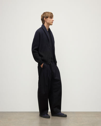 MALE MODEL WEARING JOHNSTONS OF ELGIN PIONEER SHAWL CARDIGAN NAVY & BLACK 100% CASHMERE WITH BLACK SUPERFINE CASHMERE SWEATER AND NAVY TROUSERS KAA05750Q25947