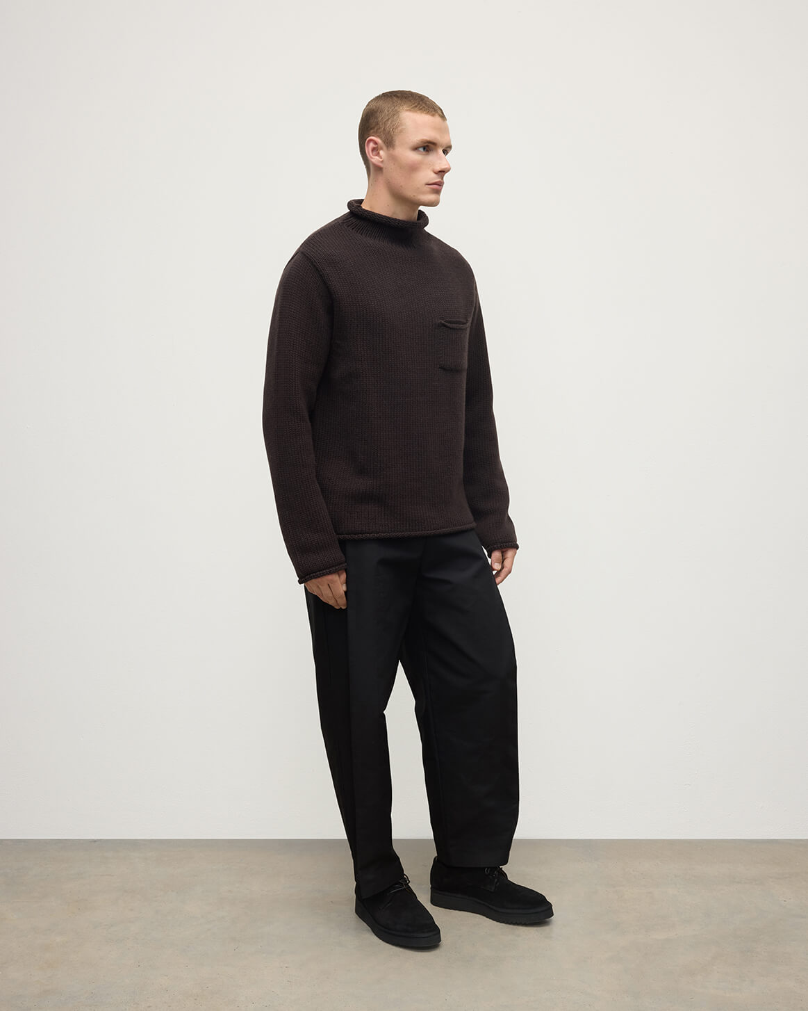 Side view of a model wearing Johnstons of Elgin AW25 Men's Knitwear Molasses Brown Cashmere Turtleneck Jumper KAB05484SB7290
