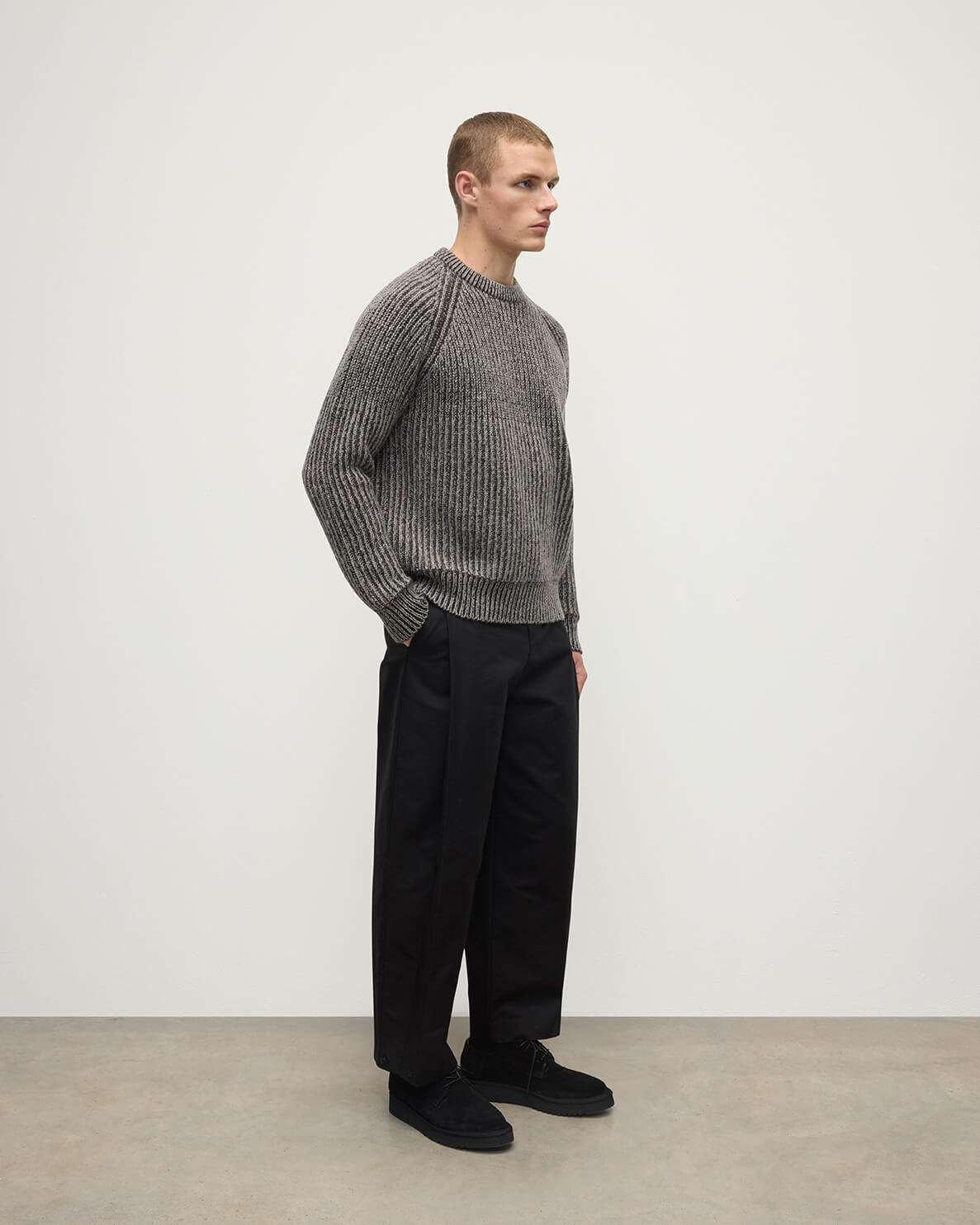 Model wearing Johnstons of Elgin AW25 Men's Knitwear Peregrine Donegal & Molasses Ribbed Donegal Cashmere Grey Jumper Side KAC05581Q25393