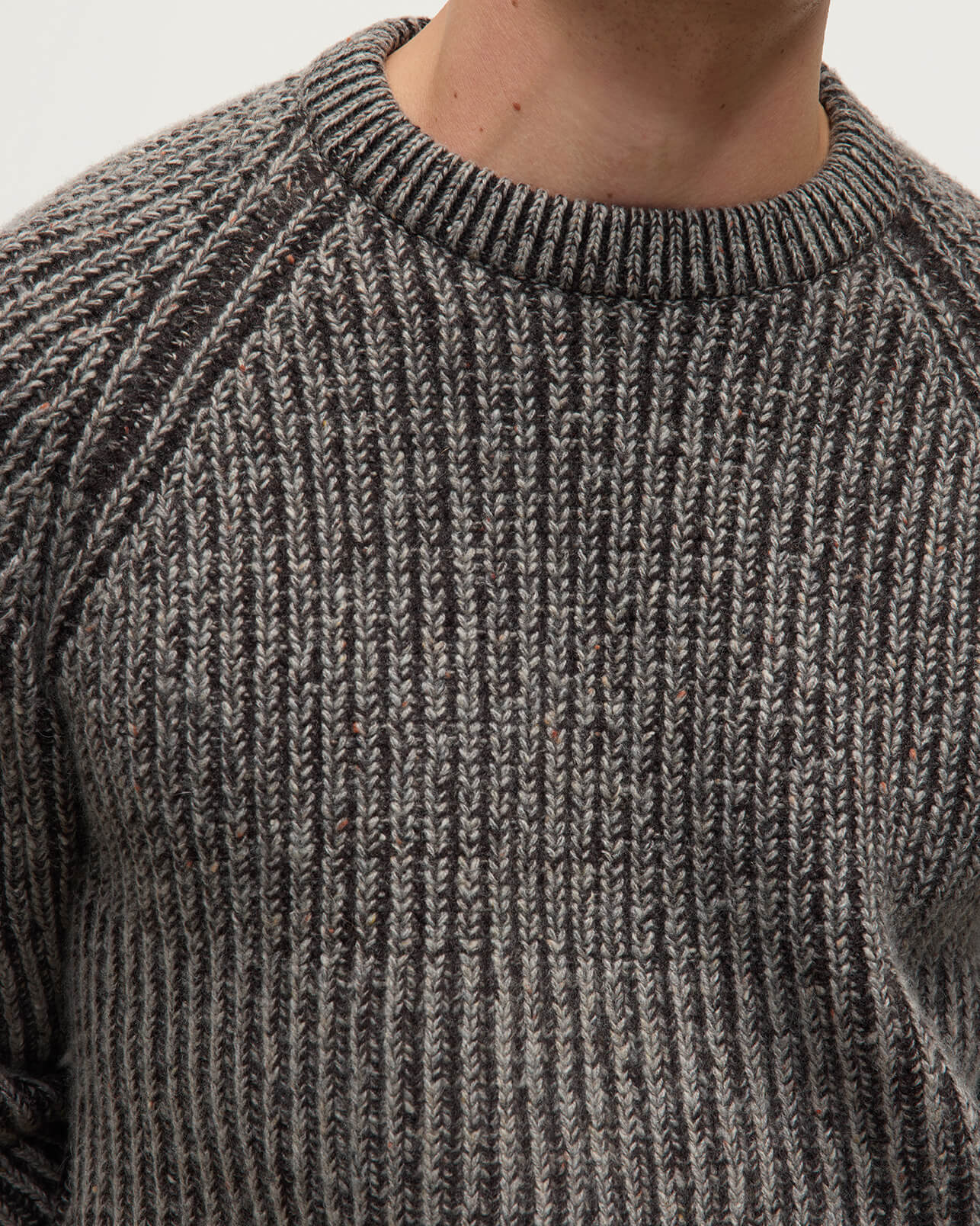 Model wearing Johnstons of Elgin AW25 Men's Knitwear Peregrine Donegal & Molasses Ribbed Donegal Cashmere Grey Jumper Details  KAC05581Q25393