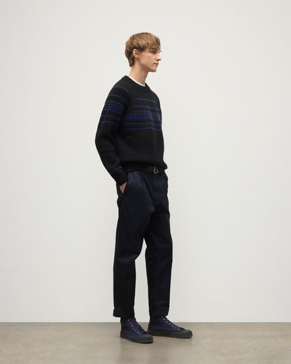 MODEL WEARS JOHNSTONS OF ELGIN  MENS SUMMIT CREW SWEATER BLACK & BLUE 100% CASHMERE OVER A WHITE T-SHIRT WITH NAVY TROUSERS KAC05752Q25949