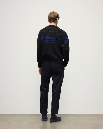 MODEL WEARS JOHNSTONS OF ELGIN  MENS SUMMIT CREW SWEATER BLACK & BLUE 100% CASHMERE OVER A WHITE T-SHIRT WITH NAVY TROUSERS KAC05752Q25949