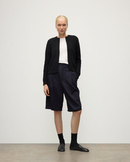 MODEL WEAR JOHNSTONS OF ELGIN WOMENS LECHT CREW CARDIGAN BLACK 100% CASHMERE OVER A WHITE T-SHIRT & LONG NAVY SHORRTS KAC05790SA7210