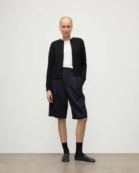 MODEL WEAR JOHNSTONS OF ELGIN WOMENS LECHT CREW CARDIGAN BLACK 100% CASHMERE OVER A WHITE T-SHIRT & LONG NAVY SHORRTS KAC05790SA7210