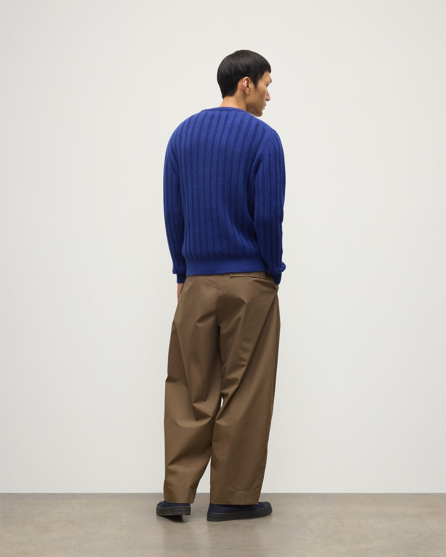 JOHNSTONS OF ELGIN MENS PEEL CREW SWEATER BLUE ON A MODEL OVER A WHITE T-SHIRT AND BROWN TROUSERS KAC05751SD5326