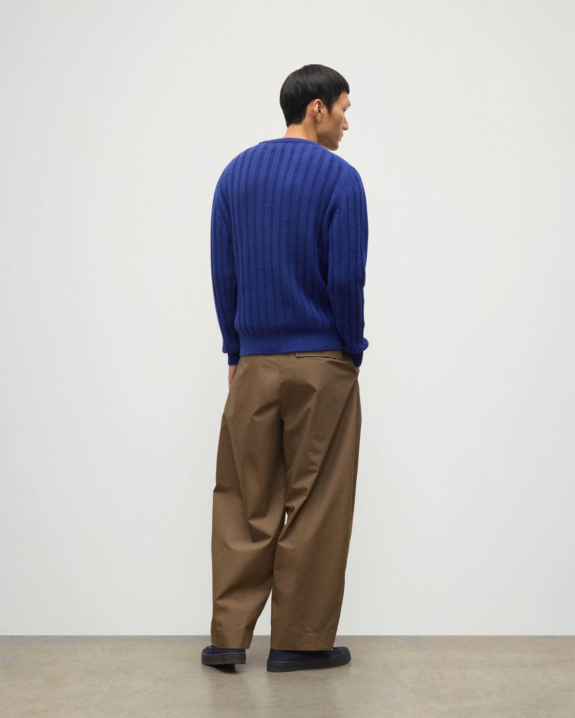 JOHNSTONS OF ELGIN MENS PEEL CREW SWEATER BLUE ON A MODEL OVER A WHITE T-SHIRT AND BROWN TROUSERS KAC05751SD5326