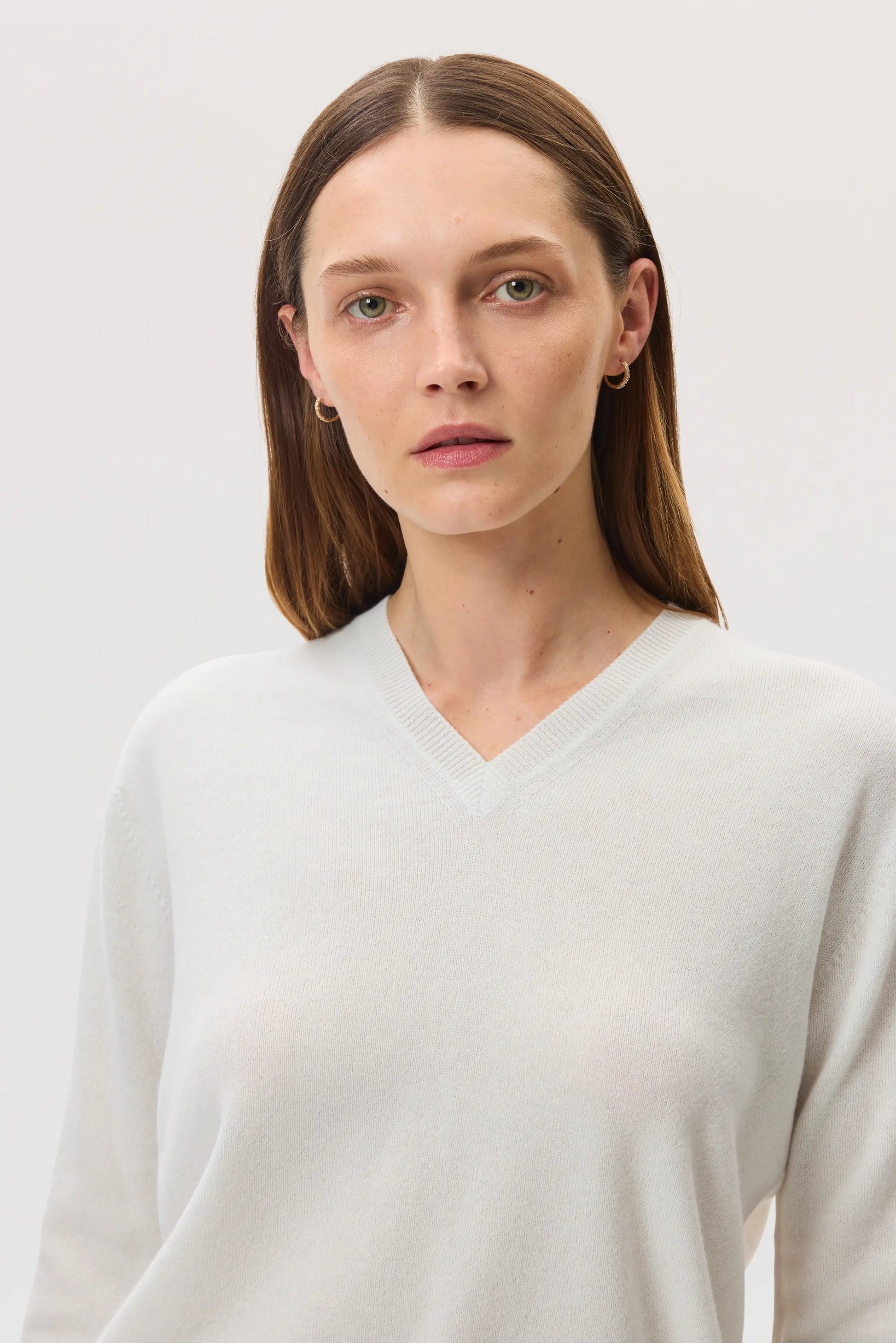 Model wearing Johnstons of Elgin SS25 Women's Knitwear White Classic Cashmere V Neck on a white background  KAI05143HA0346