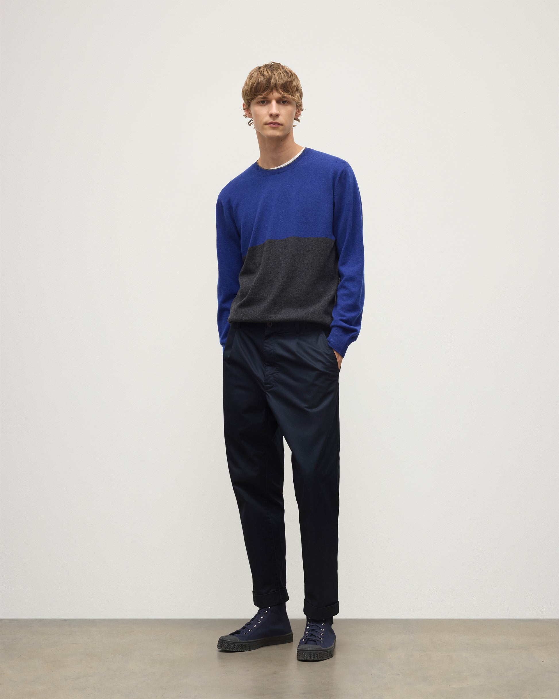 MODEL WEARING JOHNSTONS OF ELGIN MENS SHADED CREW SWEATER GREY 100% CASHMERE OVER A WHITE  T-SHIRT WITH NAVY TROUSERS KAI05232Q25945