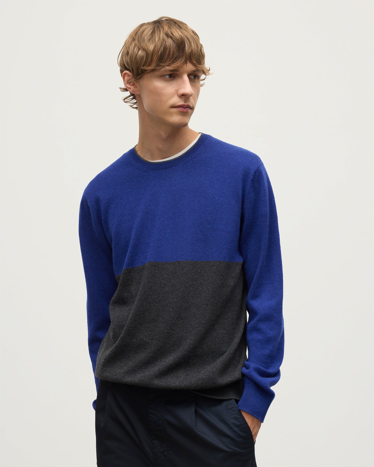 MODEL WEARING JOHNSTONS OF ELGIN MENS SHADED CREW SWEATER GREY 100% CASHMERE OVER A WHITE  T-SHIRT WITH NAVY TROUSERS KAI05232Q25945