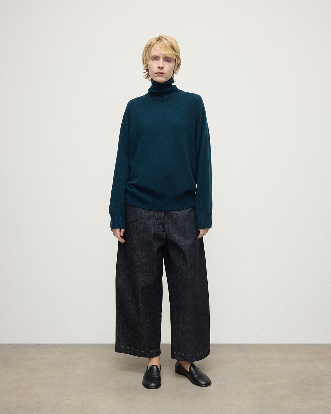 Model wears Johnstons of Elgin AW25 Women's Knitwear Bottle Green Gauzy Cashmere Green Roll Neck Jumper Front View KAI05324SC7341