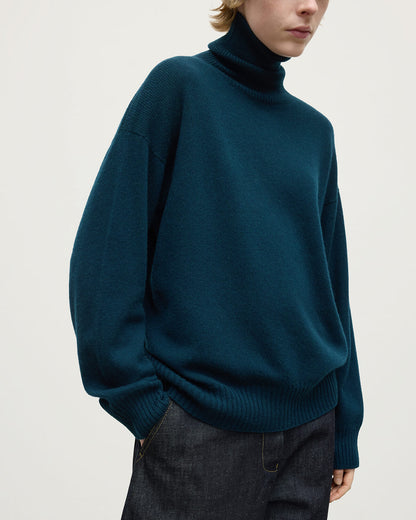 Model wears Johnstons of Elgin AW25 Women's Knitwear Bottle Green Gauzy Cashmere Green Roll Neck Jumper Details KAI05324SC7341