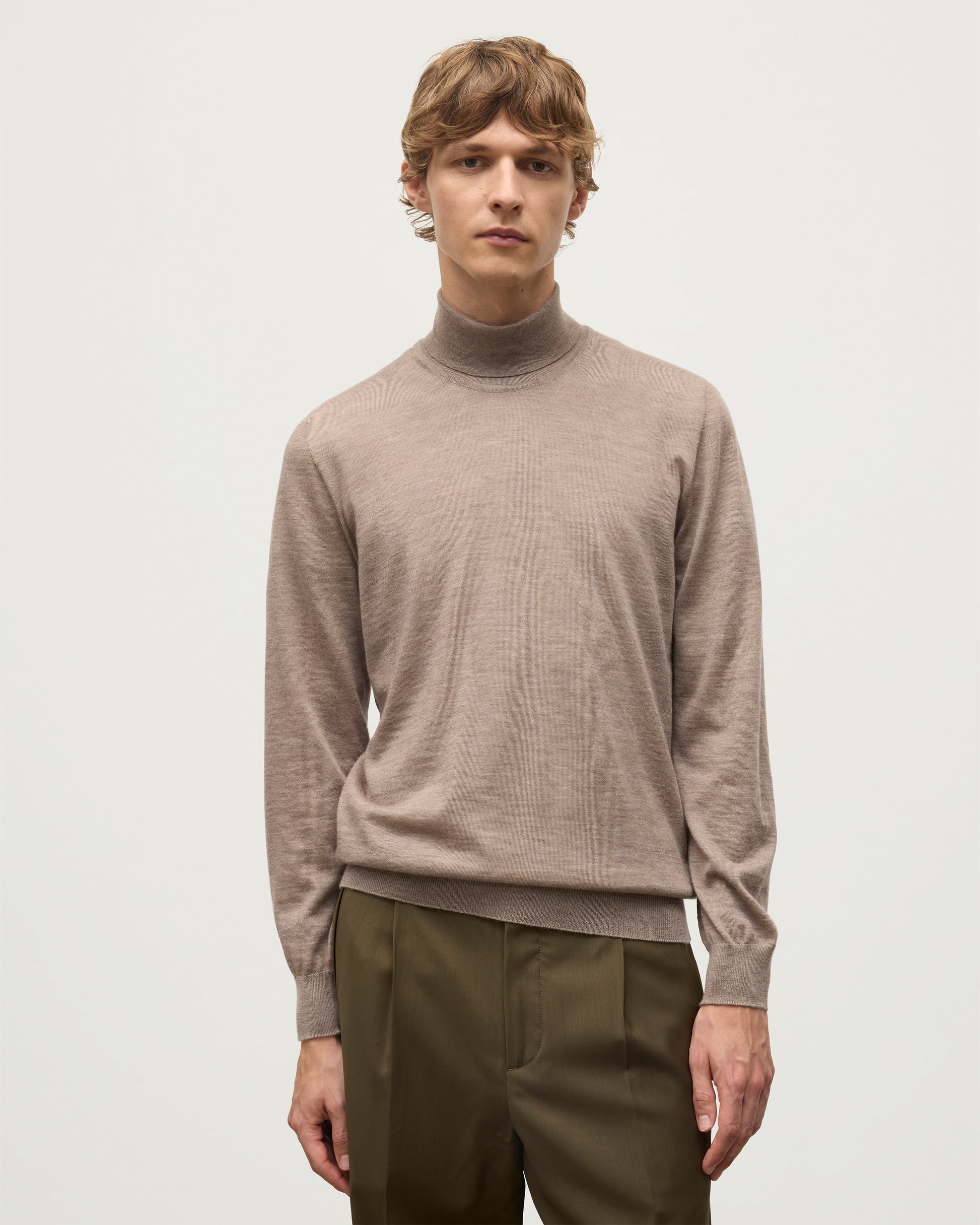 MODEL WEARING JOHNSTONS OF ELGIN MENS SUPERFINE FIN ROLL COLLAR GREY 100% SUPERFINE CASHMERE WITH OLIVE TROUSERS KAI05333HB0273