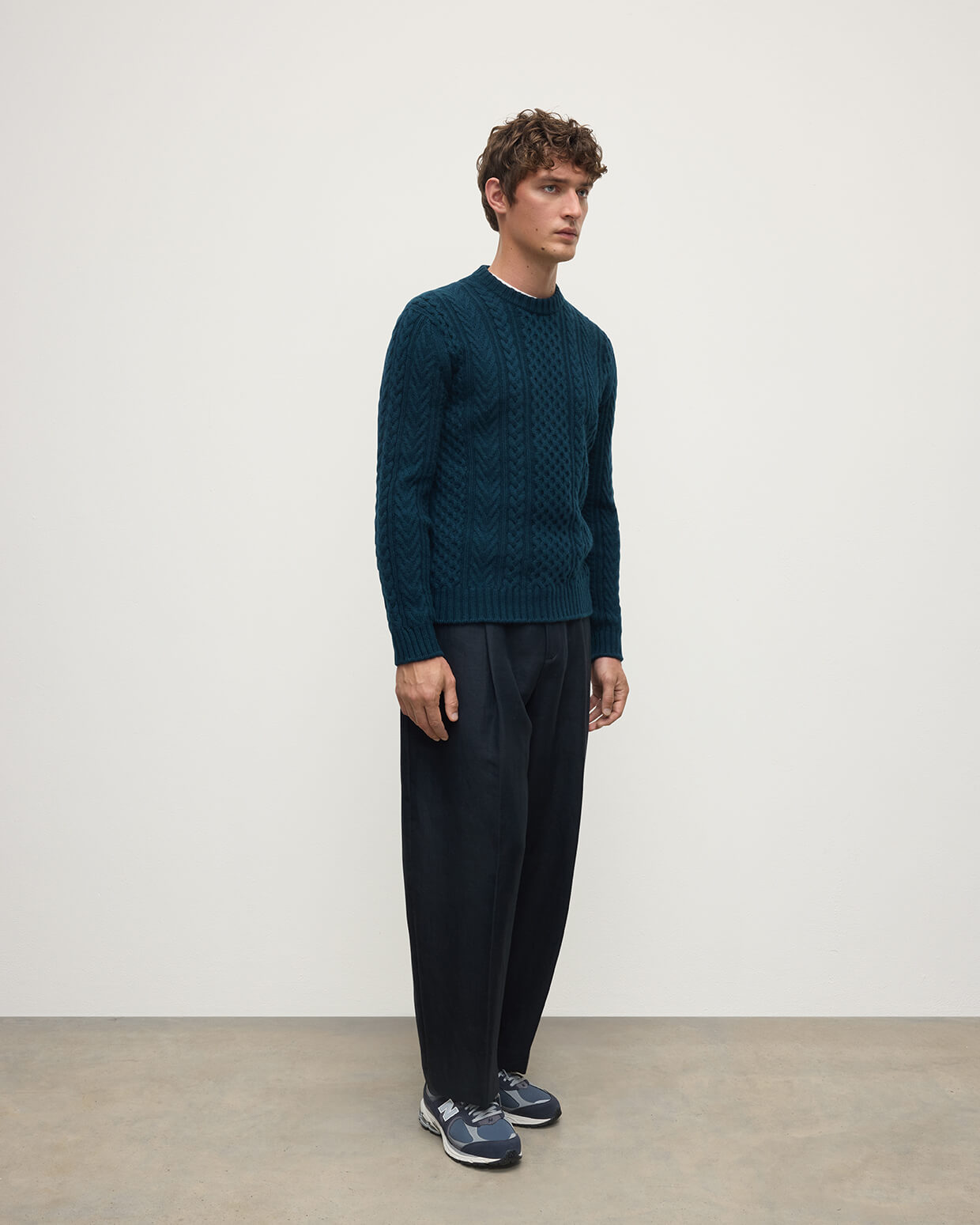 Model wearing Johnstons of Elgin AW25 Men's Knitwear Bottle Green Aran Cable Green Cashmere Jumper Side KAI05336SC7341