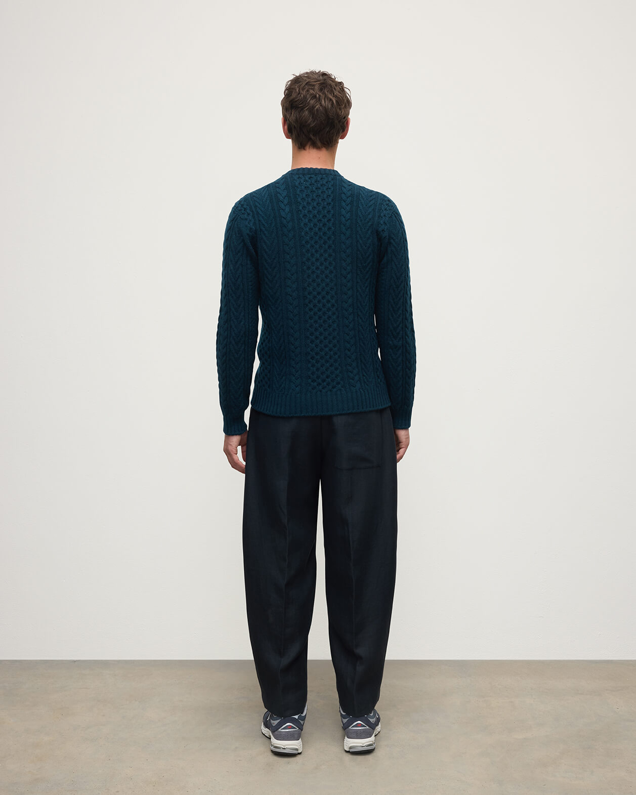Model wearing Johnstons of Elgin AW25 Men's Knitwear Bottle Green Aran Cable Green Cashmere Jumper Back  KAI05336SC7341