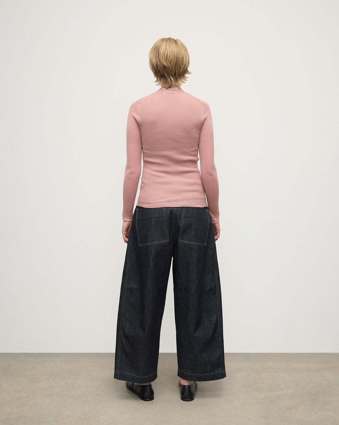 Model wears Johnstons of Elgin AW25 Women's Knitwear Nude Superfine Cashmere Pink Cardigan Back View KAI05372SE5274