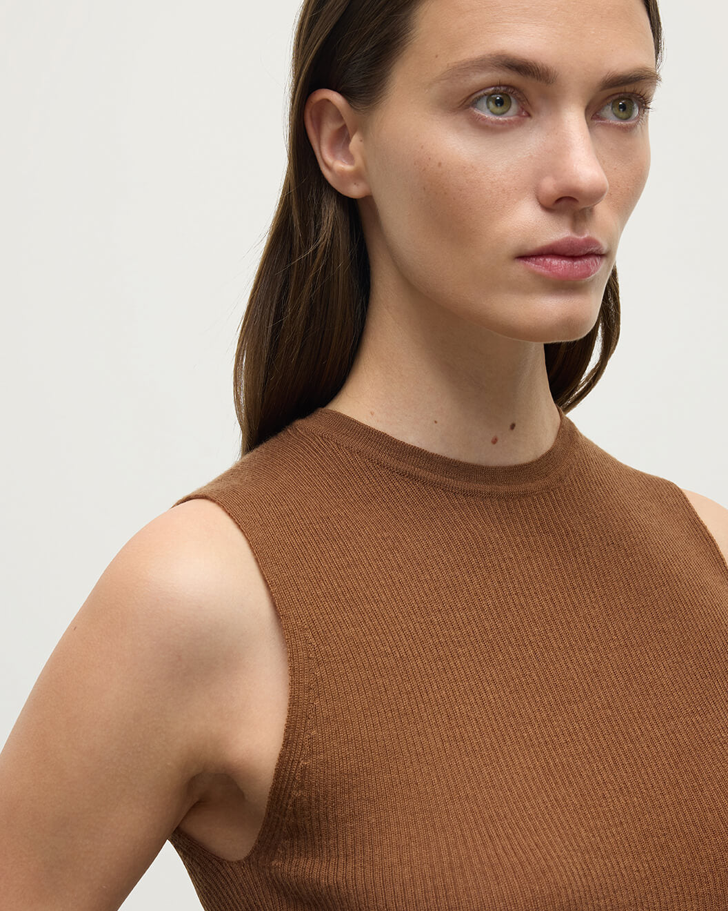 Model wears Johnstons of Elgin AW25 Women's Knitwear Dark Camel Sleeveless Camel Tank Top armhole details KAI05559SB7300