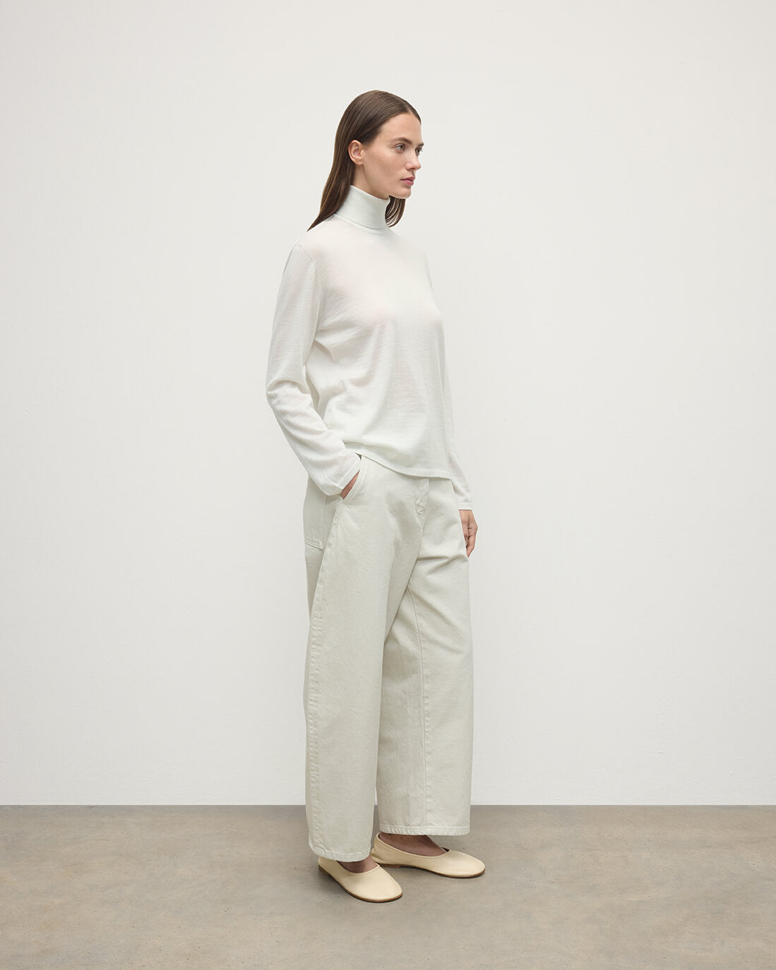 Model wearing Johnstons of Elgin AW25 Women's Knitwear Zinc White Superfine Cashmere White Roll Neck Jumper Side View  KAI05607HA0327