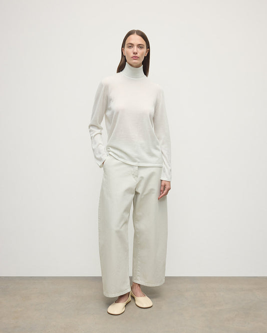 Model wearing Johnstons of Elgin AW25 Women's Knitwear Zinc White Superfine Cashmere White Roll Neck Jumper Front View  KAI05607HA0327