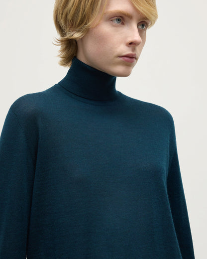 Model wears Johnstons of Elgin AW25 Women's Knitwear Bottle Green Superfine Cashmere Green Roll Neck Jumper Close Up  KAI05607SC7344
