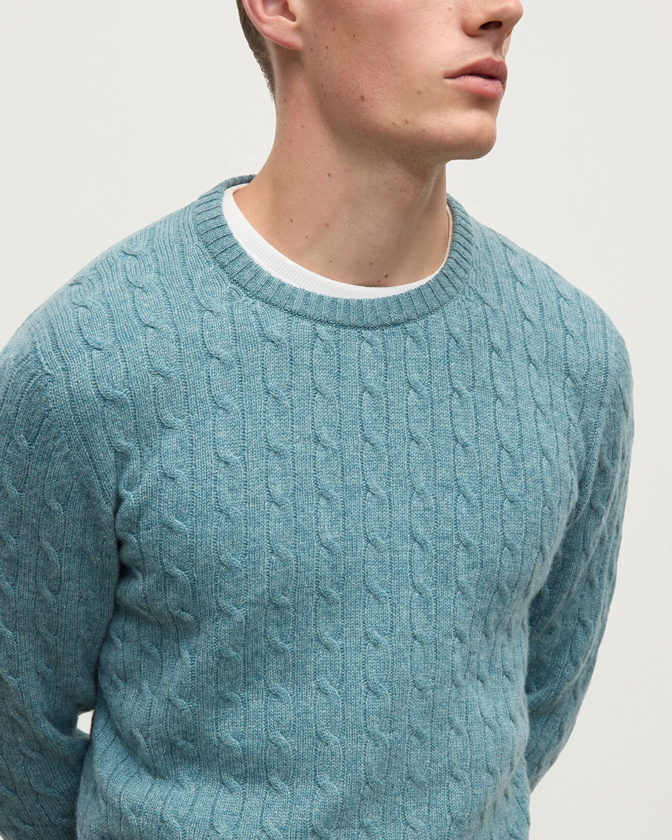 Model wearing Johnstons of Elgin AW25 Men's Knitwear Seascape Cable Knit Green Cashmere Jumper Details KAI05693HC0038
