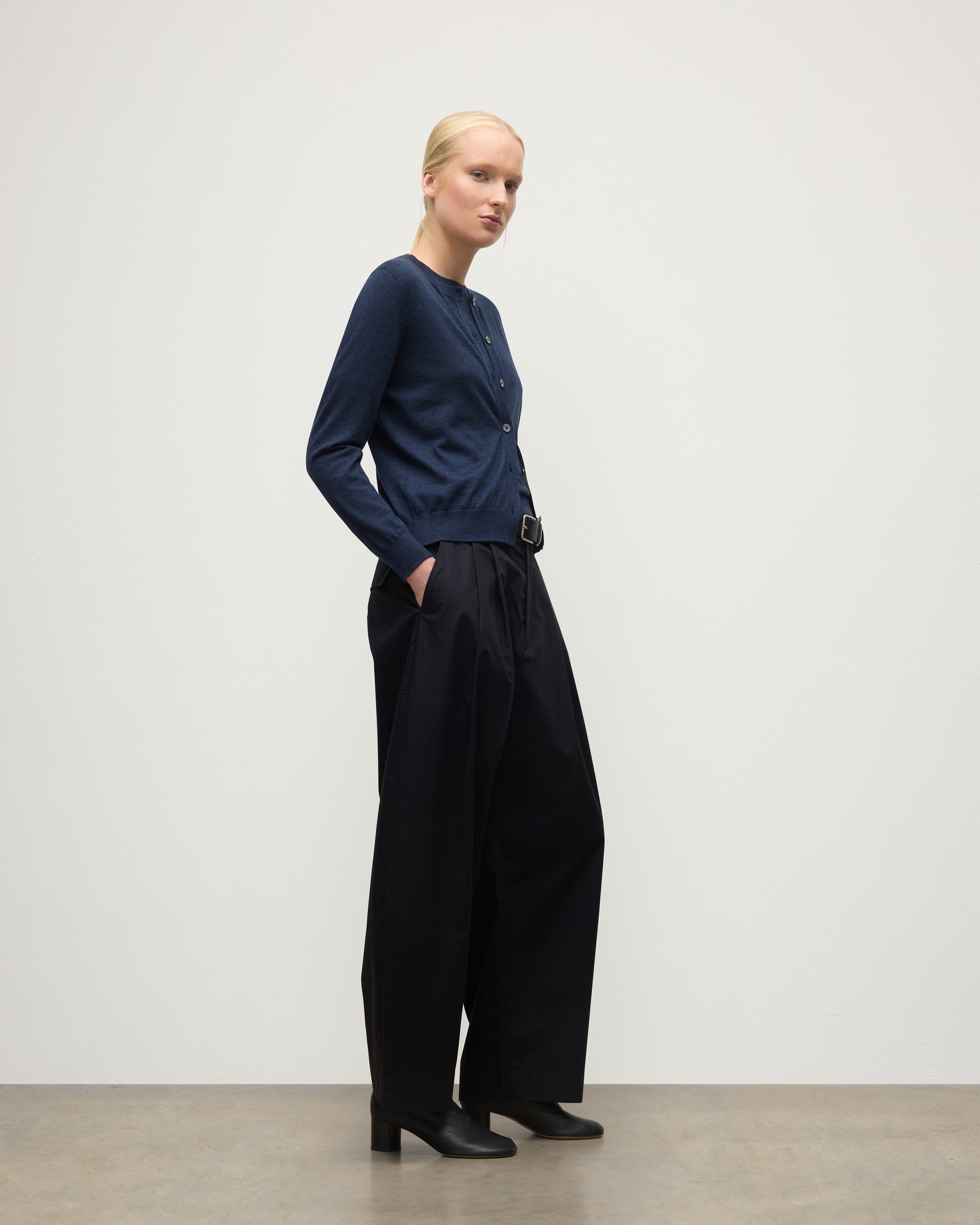 MODEL WEARS JOHHNSTONS OF ELGIN WOMENS HONOR CREW CARDIGAN NAVY 100% SUPERFINE CASHMERE OVER MATCHING CASHMERE T-SHIRT & BLACK TROUSERS KAI05708HD7350