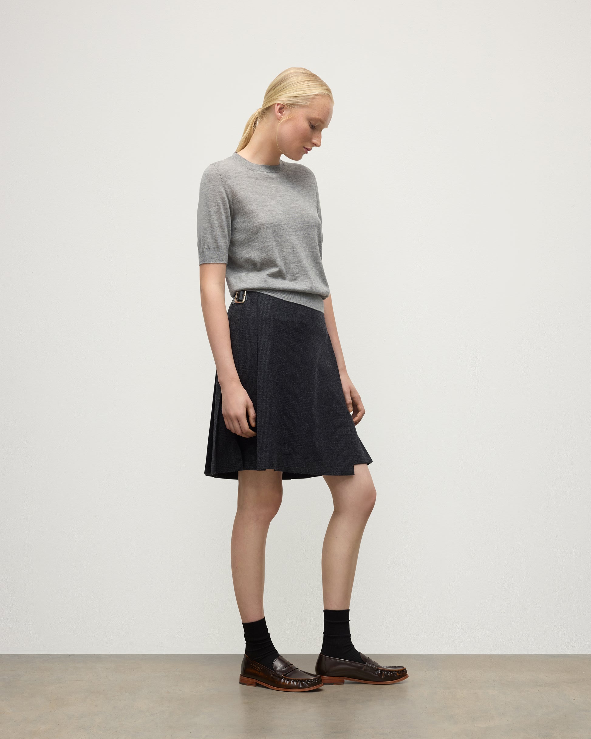 MODEL WEARS JOHNSTONS OF ELGIN WOMENS HONOR SHORT SLEEVE CREW GREY 100% SUPERFINE CASHMERE WITH SHORT LE KILT CHARCOAL KILT  KAI05712HA4253