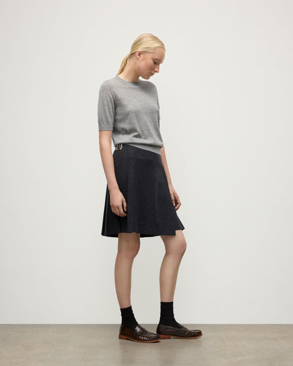 MODEL WEARS JOHNSTONS OF ELGIN WOMENS HONOR SHORT SLEEVE CREW GREY 100% SUPERFINE CASHMERE WITH SHORT LE KILT CHARCOAL KILT  KAI05712HA4253