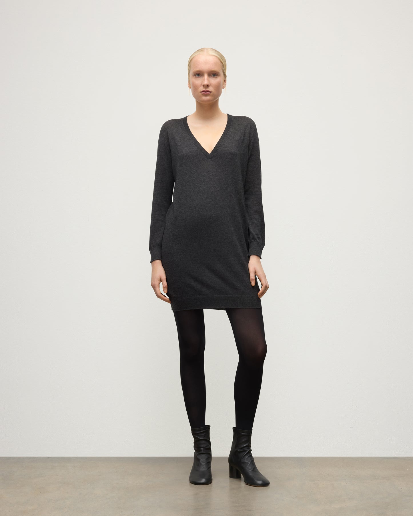 MODEL WEARING JOHNSTONS OF ELGIN WOMENS ELISE VEE SWEATER GREY 100% SUPERFINE CASHMERE WITH BLACK TIGHTS AND BOOTS KAI05715HA7218