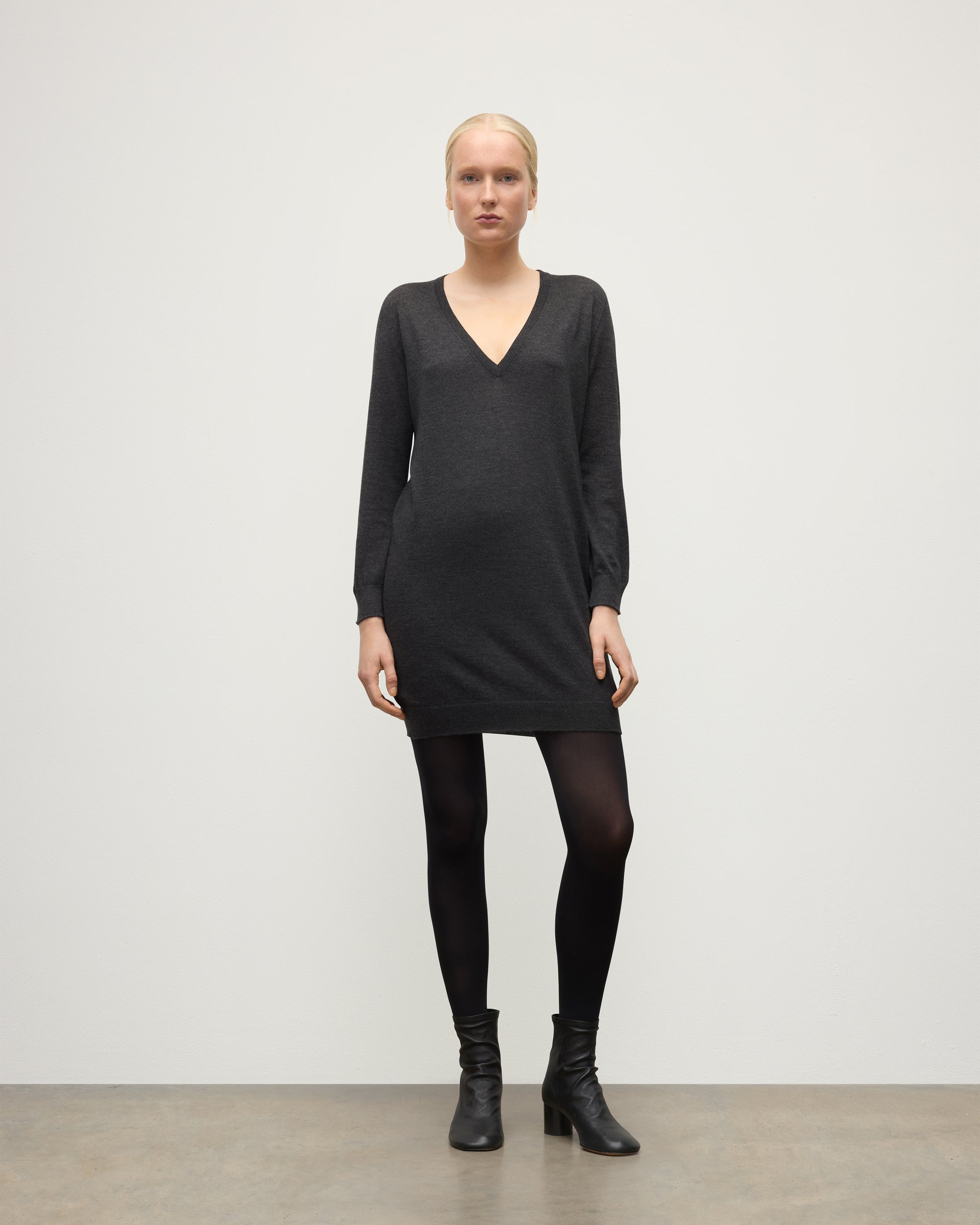 MODEL WEARING JOHNSTONS OF ELGIN WOMENS ELISE VEE SWEATER GREY 100% SUPERFINE CASHMERE WITH BLACK TIGHTS AND BOOTS KAI05715HA7218