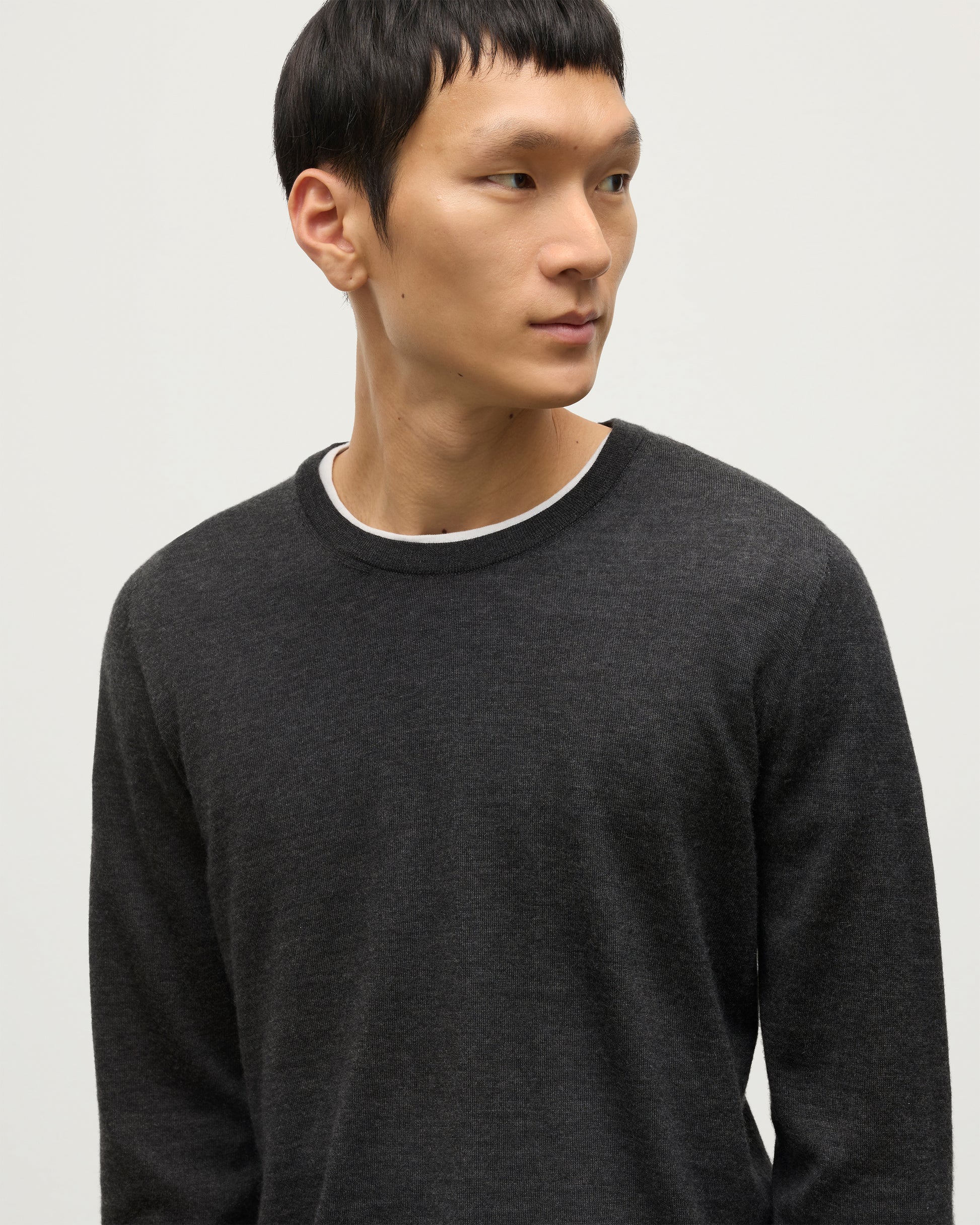 MODEL WEARS JOHNSTONS OF ELGIN MENS FIN SUPERFINE CREW GREY 100% SUPERFINE CASHMERE OVER A WHITE T-SHIRT  KAI05717HA7218