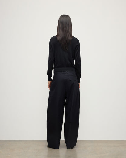 BACK VIEW OF MODEL WEARING JOHNSTONS OF ELGIN WOMENS ELLA SCOOP SWEATER BLACK WITH BLACK TROUSERS KAI05723SA7146