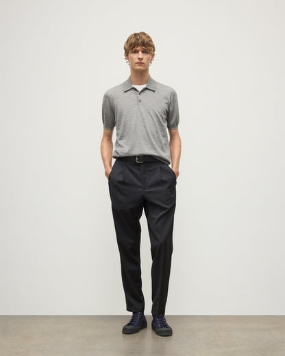 MODEL WEARS JOHNSTONS OF ELGIN MENS FIN SHORT SLEEVE SUPERFINE POLOSHIRT GREY OVER A WHITE T-SHIRT WITH NAVY TROUSERS KAI05741HA4253