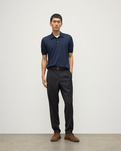 MODEL WEARS JOHNSTONS OF ELGIN MENS FIN SHORT SLEEVE SUPERFINE POLOSHIRT NAVY OVER A WHITE T-SHIRT WITH NAVY TROUSERS KAI05741HD7350