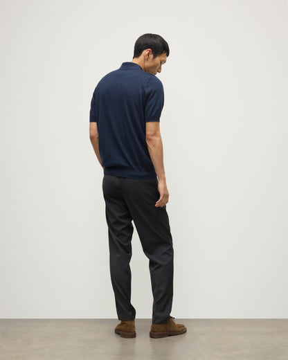 MODEL WEARS JOHNSTONS OF ELGIN MENS FIN SHORT SLEEVE SUPERFINE POLOSHIRT NAVY OVER A WHITE T-SHIRT WITH NAVY TROUSERS KAI05741HD7350