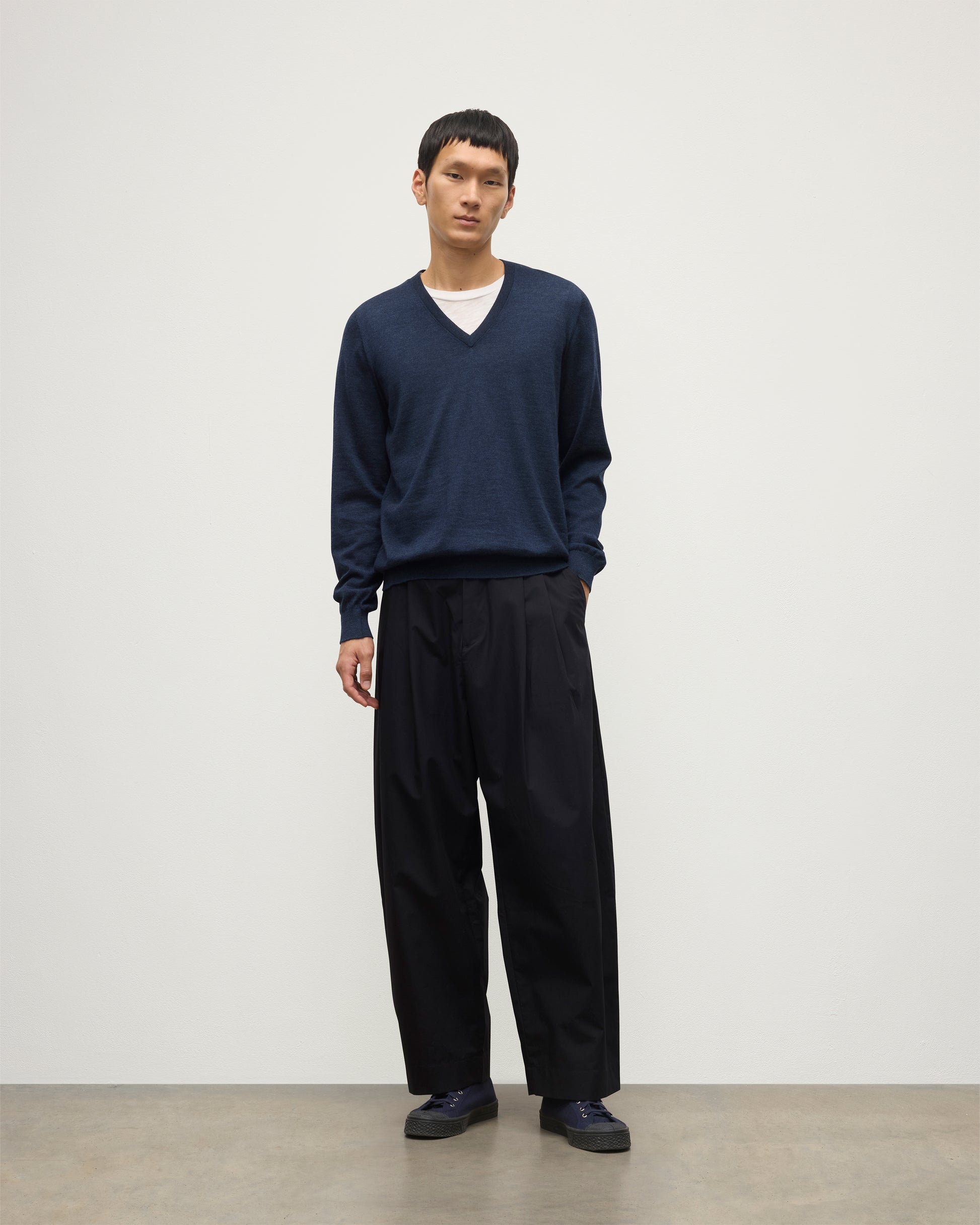 MENS FIN SUPERFINE VEE NECK NAVY 100% SUPERFINE CASHMERE BY JOHNSTONS OF ELGIN, WORN OVER A WHITE T-SHIRT WITH NAVY TROUSERS KAI05744HD7350
