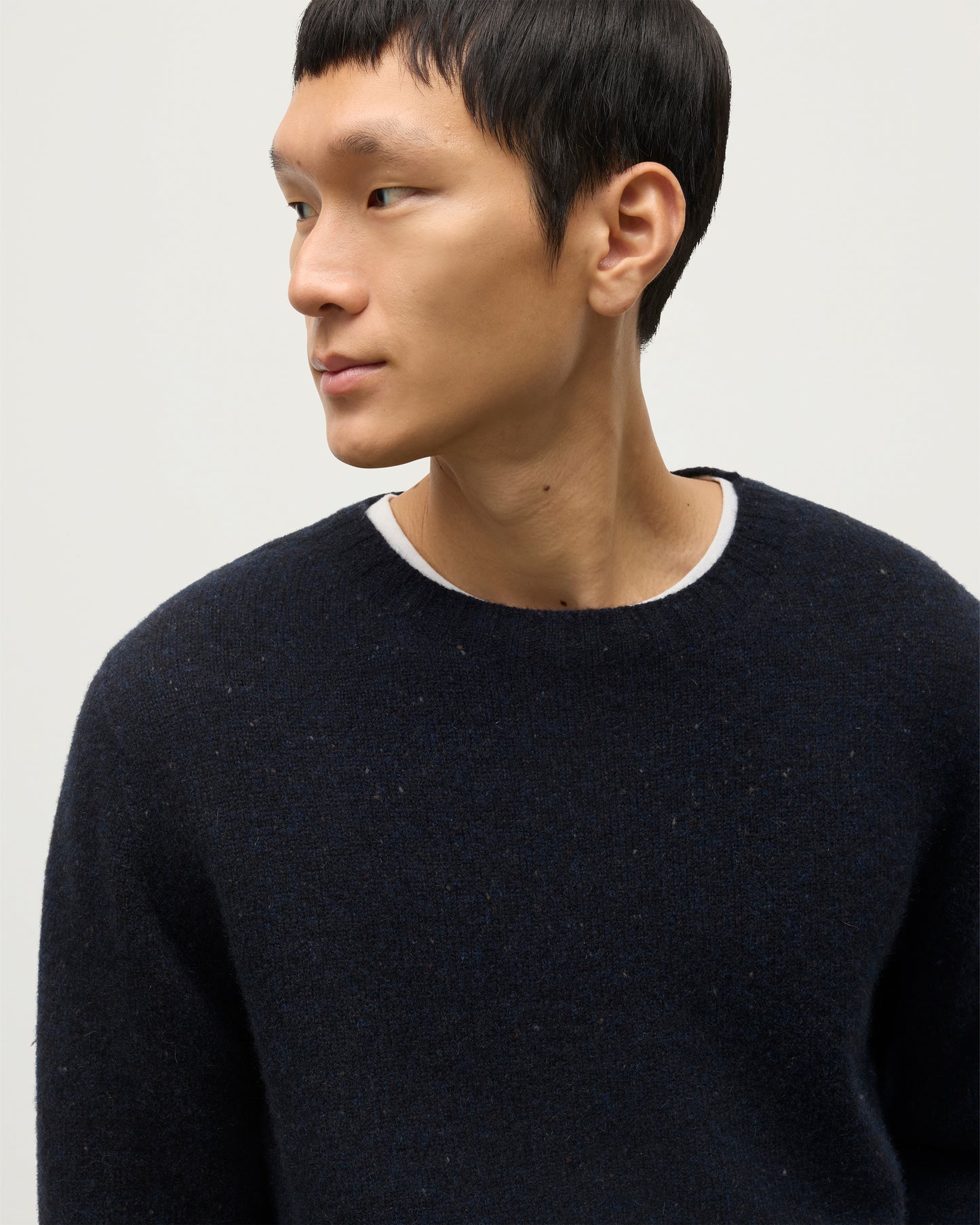 MODEL WEARS JOHNSTONS OF ELGIN  MENS TIREE CREW SWEATER BLUE 100% DONEGAL CASHMERE WITH WHITE JEANS KAI05755HD7348