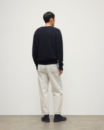MODEL WEARS JOHNSTONS OF ELGIN  MENS TIREE CREW SWEATER BLUE 100% DONEGAL CASHMERE WITH WHITE JEANS KAI05755HD7348
