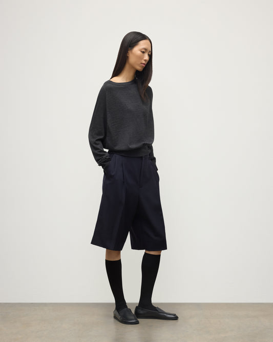 MODEL WEARING JOHNSTONS OF ELGIN WOMENS FINOLA SWEATER GREY 100% SUPERFINE CASHMERE  WITH BLACK LONG SHIRTS, SOCKS AND LOAFERS KAI05789HA7218