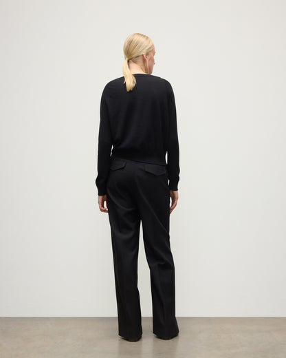 BACK OF JOHNSTONS OF ELGIN WOMENS FINOLA SWEATER BLACK 100% SUPERFINE CASHMERE ON A MODEL WITH BLACK TROUSERS AND BOOTS KAI05789SA7146